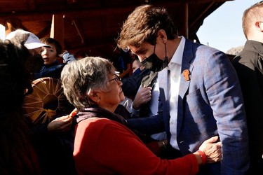 Tk'emlups Elder and band member Dianne Morgan embraces Canada's Prime Minister Justin Trudeau as he leaves the Tk'emlups PowWow Arbour in B.C., Oct. 18, 2021.