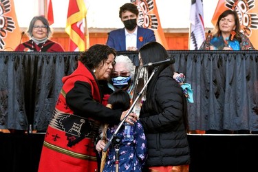 Tk'emlups band member Ashley Michel is embraced by her family after speaking at the Tk'emlups PowWow Arbour as Canada's Prime Minister Justin Trudeau looks on in B.C., Oct. 18, 2021.