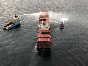 Tugboats pour water on the container ship Zim Kingston after it caught fire the day before off the coast of Victoria, British Columbia, Canada October 24, 2021.  Canadian Coast Guard/Handout via REUTERS.   THIS IMAGE HAS BEEN SUPPLIED BY A THIRD PARTY.