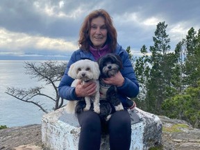 Dianne Donohue holding her two Havanese dogs, Murphy, left, and Daisy. Daisy was attacked and killed by two large dogs at Island View Beach Park on Monday.