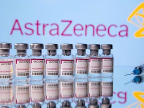 Vials labelled "Astra Zeneca COVID-19 Coronavirus Vaccine" and a syringe are seen in front of a displayed AstraZeneca logo, in this illustration photo taken March 14, 2021.