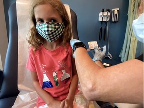 Lydia Melo, 7, is inoculated with one of two reduced doses of the Pfizer BioNTech vaccine during a trial at Duke University in Durham, North Carolina on Sept. 28, 2021.