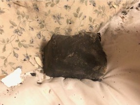 A meteorite rests on Ruth Hamilton's bed after it crashed through her ceiling while she slept on Oct. 4.