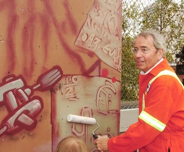 Vancouver City unveils a new graffiti program in 2002. Here Mayor Philip Owen gives a protective coat to a mural to help foil other artists from painting over it.