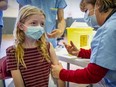 Eleven-year-old Katherine Love of Beaconsfield, Quebec, gets vaccinated at a clinic for children between five and 11 years old at Beurling Academy in the Verdun borough of Montreal on Saturday Nov. 27, 2021.