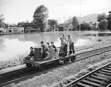 1948 Fraser River Flood - Rosedale - A group of people ride a handcar along train tracks next to flood waters. 1948. Vancouver Sun.