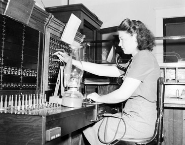 1948 Fraser River Flood - Rosedale - A switchboard operator works by lamplight. 1948. Vancouver Sun.