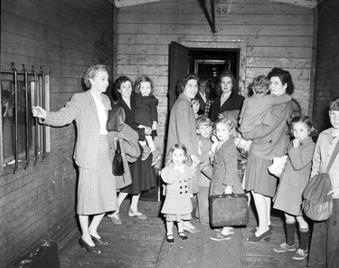 1948 Fraser River Flood - Rosedale - A group of women and children gather with luggage inside what may be a train car. 1948. Vancouver Sun.