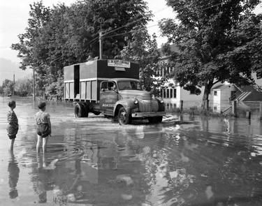 1948 Fraser River Flood - Rosedale - A baby plays on the ground next to a truck full of cargo. 1948. Vancouver Sun.