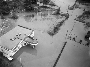 1948 Fraser River Flood - Rosedale - Aerial view of a small boat floating near buildings. 1948. Vancouver Sun.