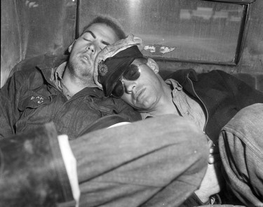 1948 Fraser River Flood - Sumas - Yarrows - Two servicemen catch some shut-eye, using each other as pillows. 1948. Vancouver Sun.
