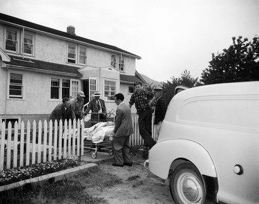 1948 Fraser River Flood - Sumas - Yarrows - Men wheel a man on a gurney from a house toward an ambulance or hearse. 1948. Vancouver Sun. (