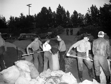 1948 Fraser River Flood - Sumas - Yarrows - Adolescent and teenage boys work together to fill sandbags. 1948. Vancouver Sun.