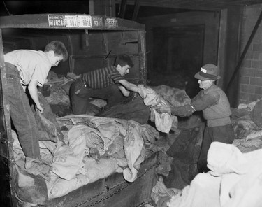 1948 Fraser River Flood - Vedder Canal - People work at night to unload bags to be filled with sand. 1948. Vancouver Sun. (48/1179) [PNG Merlin Archive]