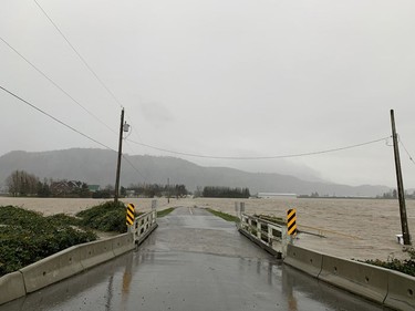 Photos of Bouwman Road in Abbotsford, where a drainage ditch has overtopped the road.