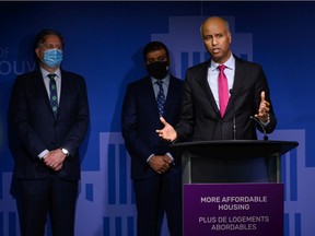Federal housing minister Ahmed Hussen (right) speaks at a press conference on housing at Vancouver city hall, while Vancouver Mayor Kennedy Stewart (left) watches, on Nov. 15, 2021. Credit:  Milos Tosic - CNW