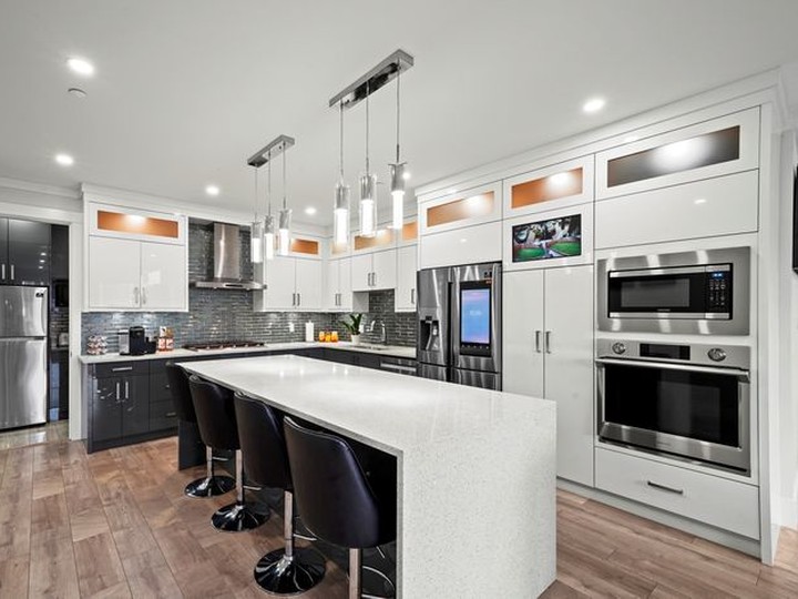  Samsung appliances, quartz counters and an oversized island with a waterfall countertop in the kitchen.