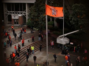 A ceremonial flagged is raised as people attend the Xe xe Smun’ eem-Victoria Orange Shirt Day Every Child Matters ceremony to honour victims of the Canadian Indian residential school system in Victoria, B.C., on Sept. 30. THE CANADIAN PRESS/Chad Hipolito