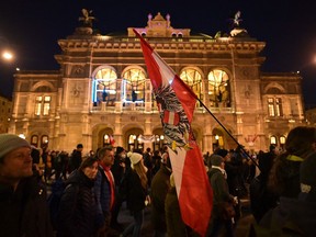 Demonstrators pass by the State Opera during a rally held by Austria's far-right Freedom Party FPOe against the measures taken to curb the coronavirus (Covid-19) pandemic, at Maria Theresien Platz square in Vienna, Austria on November 20, 2021. - Austria will impose a lockdown for all and make vaccinations mandatory, Austria's Chancellor Schallenberg announced on November 19, making the country the first in the EU to take such stringent measures as coronavirus cases spiral.