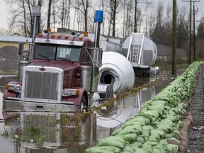 A truck gets swallowed up by rising flood waters from the United States as waters cross the border into Abbotsford, Monday, Nov. 29, 2021.