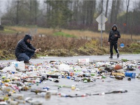 Debris from receding flood waters is pictured along a road as heavy rains form an atmospheric river continue in Abbotsford, B.C., Tuesday, November 30, 2021.