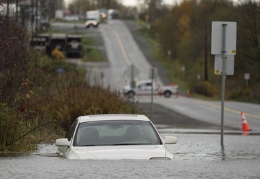 A vehicle is submerged in flood waters along a road in Abbotsford, B.C., Monday, Nov. 15, 2021.
