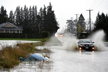 A car sits in a ditch on a flooded stretch of road in Chilliwack, Nov. 15, 2021.
