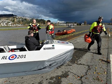 Central Fraser Valley Search and Rescue members speak with the operator of a hovercraft on the Trans Canada highway after rainstorms caused flooding and landslides in Abbotsford, British Columbia, Canada November 16, 2021.