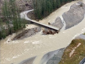 FILE PHOTO: A swollen creek flows under a washed out bridge at the Carolin Mine interchange with Coquihalla Highway 5 after devastating rain storms caused flooding and landslides, near Hope, British Columbia, Canada November 17, 2021.