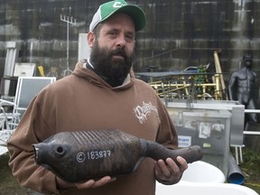 Dov Dimant, co-owner of Capital Salvage in Vancouver, holds a catalytic converter in his yard.