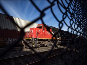 CN Rail locomotives are moved on tracks past cargo containers sitting on idle train cars at port in Vancouver, on Friday, February 21, 2020.