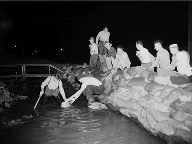 1948 Fraser River Flood - Vedder Canal - Men work outside at night to stack sandbags. 1948. Vancouver Sun.