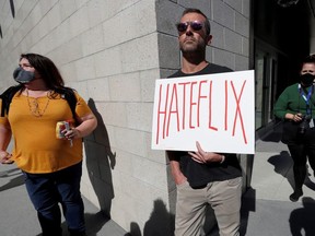 A man holds a placard as he attends a rally in support of the Netflix transgender employee walkout "Stand Up in Solidarity" to protest the streaming of comedian Dave Chappelle's new comedy special, in Los Angeles, California, U.S. October 20 2021.