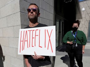 A man holds a placard as he attends a rally in support of a walkout by Netflix transgender employees to protest the streaming of comedian Dave Chappelle's new comedy special.