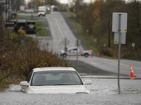 A vehicle is submerged in flood waters along a road in Abbotsford, B.C. on Nov. 15, 2021.