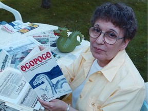 Arlene Gaal holds her second book about the legendary lake monster Ogopogo among dozens of newspaper clippings in 2000.