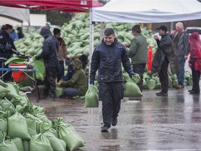 Volunteers fill sand bags to be shipped to flood-prone areas in the Sumas prairie and other at-risk areas in and around Abbotsford on Nov. 30, 2021.