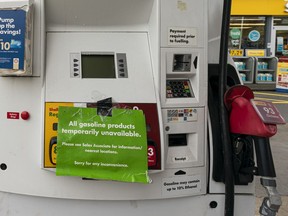 Signs indicating the lack of gasoline are placed on gas station pumps in Vancouver, BC, November, 20, 2021.