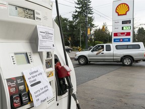 Signs indicating the temporary fuel restrictions and the lack of gasoline are seen placed on gas station pumps in Vancouver, BC, November, 20, 2021.