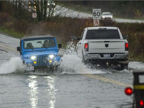 Drivers brave the flooded road on South Fraser Way near Townline Road in Abbotsford, BC. Nov. 28, 2021.
