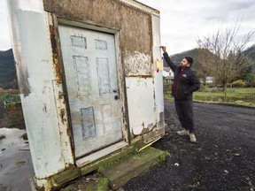 Sunny Sekhon shows the height reached by floodwaters at his Abbotsford blueberry farm.