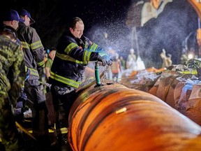 Abbotsford firefighters pump water to inflate a Tiger Dam that was built across Highway 1 at Cole Road in Abbotsford, B.C.