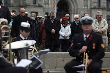 People take part in a Remembrance Day service at the cenotaph on the grounds of the legislature in Victoria, B.C., on Thursday, Nov. 11, 2021.