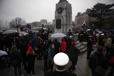 People take part in a Remembrance Day service at the cenotaph on the grounds of the legislature in Victoria, B.C., on Thursday, Nov. 11, 2021.