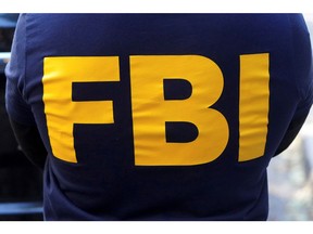 FILE PHOTO: An FBI logo is pictured on an agent's shirt during the U.S. law enforcements raid on Russian oligarch Oleg Deripaska's property in the Manhattan borough of New York City, New York, U.S. October 19, 2021.  REUTERS/Carlo Allegri/File Photo