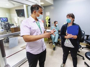 Dr. Omar Ahmad, department head for emergency and critical care for Island Health, talks to ICU registered nurse Carrie Homuth, who manages the adult intensive care unit and high-acuity unit for Royal Jubilee.