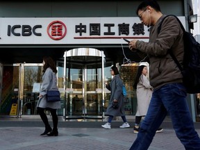 People walk past a branch of Industrial and Commercial Bank of China (ICBC) in Beijing, China April 1, 2019. ]