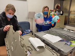 CABE youth workers Jill Allan (left) and Erin Watkins unpacking gifts for young mums and babies delivered by London Drugs as part of the company's support for Adopt-A-School.