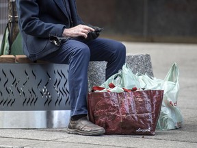 File photo of a shopper with plastic bags. Vancouver's ban on plastic bags starts Saturday.