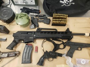 A man and woman are under investigation by gang police after a large seizure of guns and drugs at a Langley home Thursday.